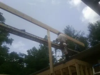 Carpenter setting a ridge beam over a new addition frame — Ice Dam Removal by Roofing Brothers in Kennedyville