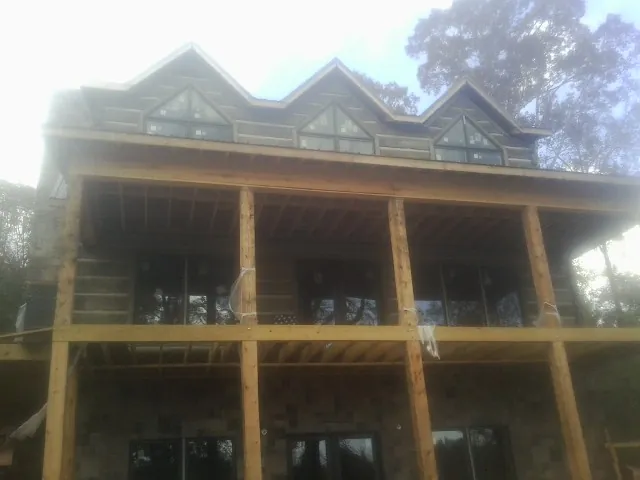 Dormers and porch framing on a large log home under construction — Roof Coating work by our crew in Kennedyville