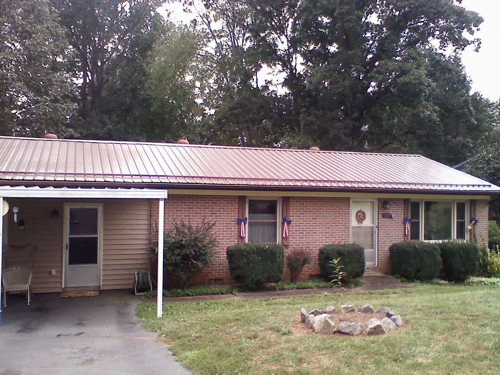 Bronze metal roof and carport on a brick ranch home — Roof Repair work by our crew in Kennedyville
